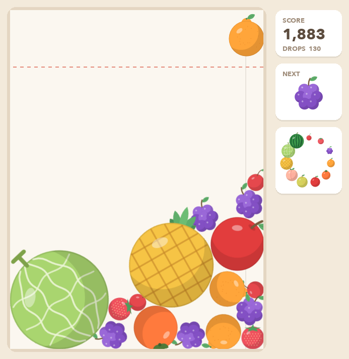 The Suika game we built. Melon, pineapple, apples and other fruit are stacked at the bottom of the box, with a dekopon waiting at the top to be dropped